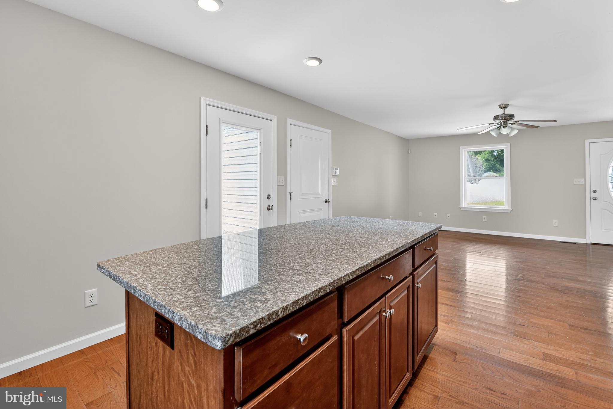 1 Spring Avenue Temple, PA 19560 - Photo 9 of 34 a kitchen with granite countertop hallway with wooden floor and chandelier