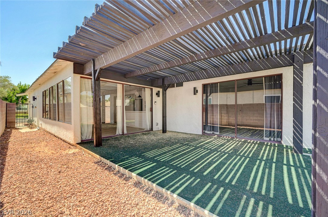 4840 Summerhill Road Las Vegas, NV 89121 - Photo 39 of 56 A spacious pergola covers an artificial turf patio, offering an inviting outdoor living area.
