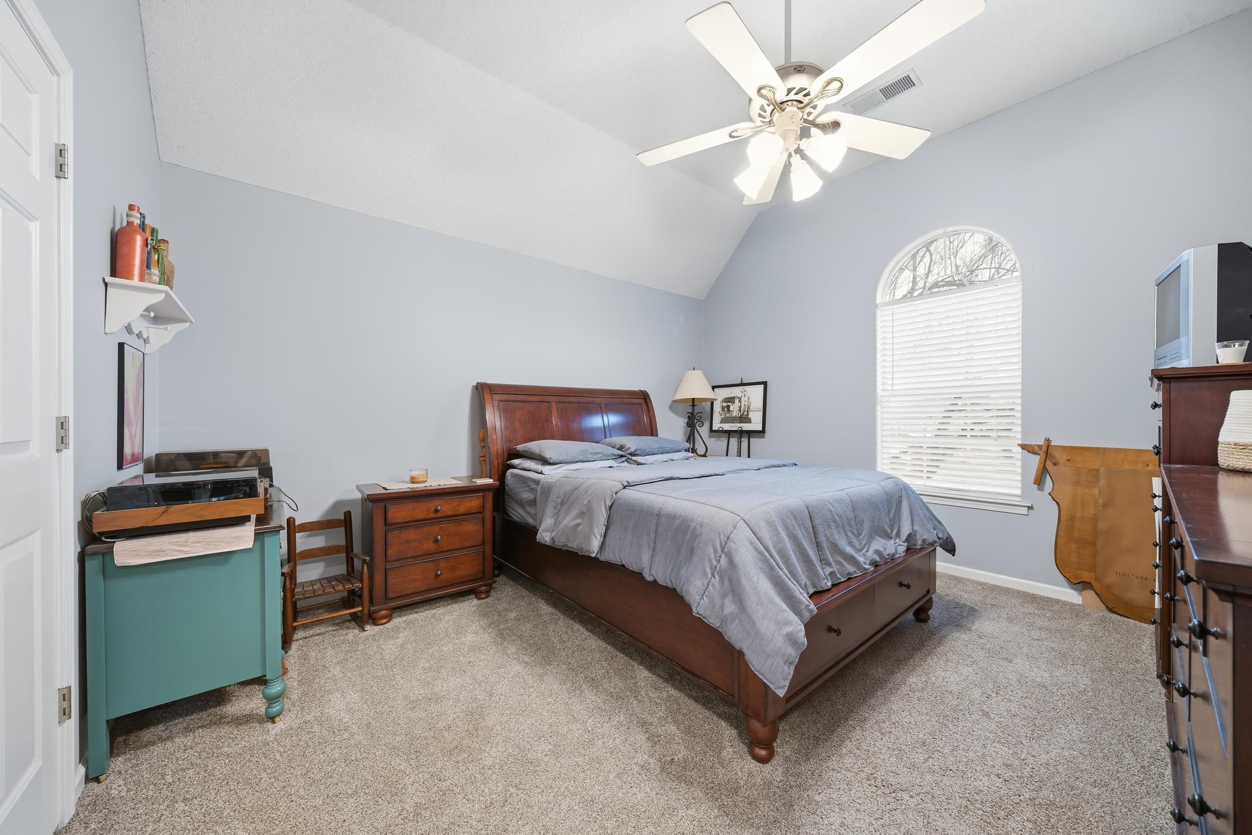 Bedroom featuring light carpet, a ceiling fan, and lofted ceiling