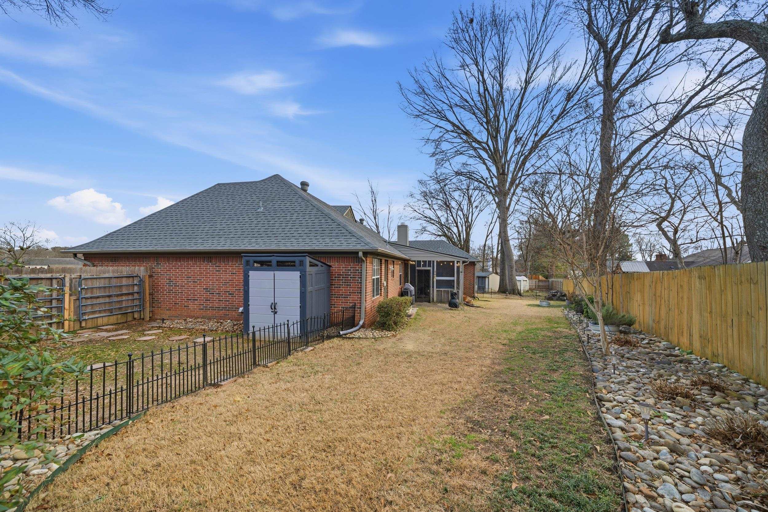 307 John Cove Collierville, TN 38017 - Photo 12 of 25 Back of house featuring a fenced backyard, brick siding, roof with shingles, and a chimney