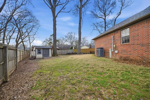 a backyard of a house with large trees and outdoor seating