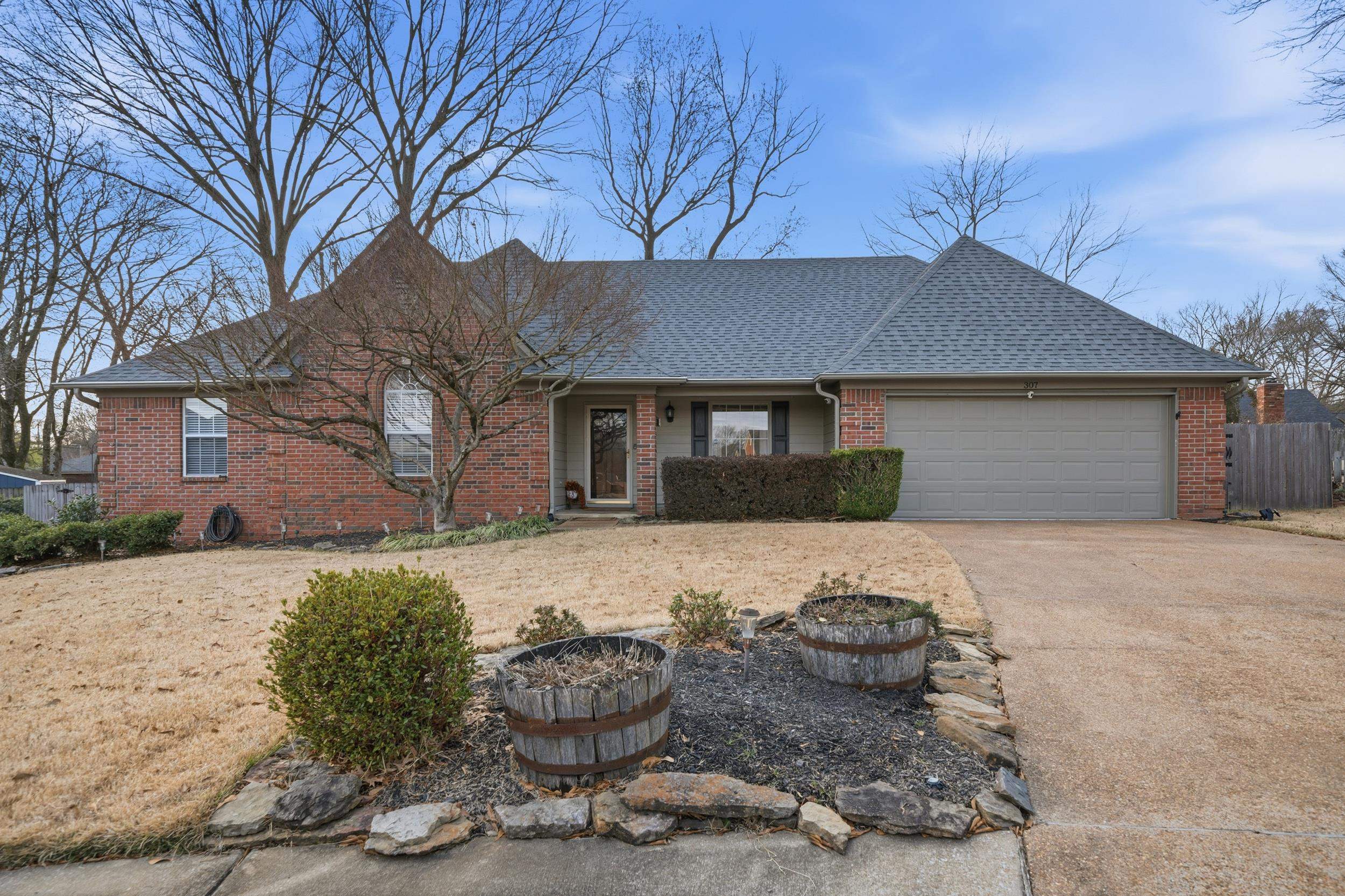 307 John Cove Collierville, TN 38017 - Photo 15 of 25 View of front facade with brick siding, concrete driveway, roof with shingles, and an attached garage