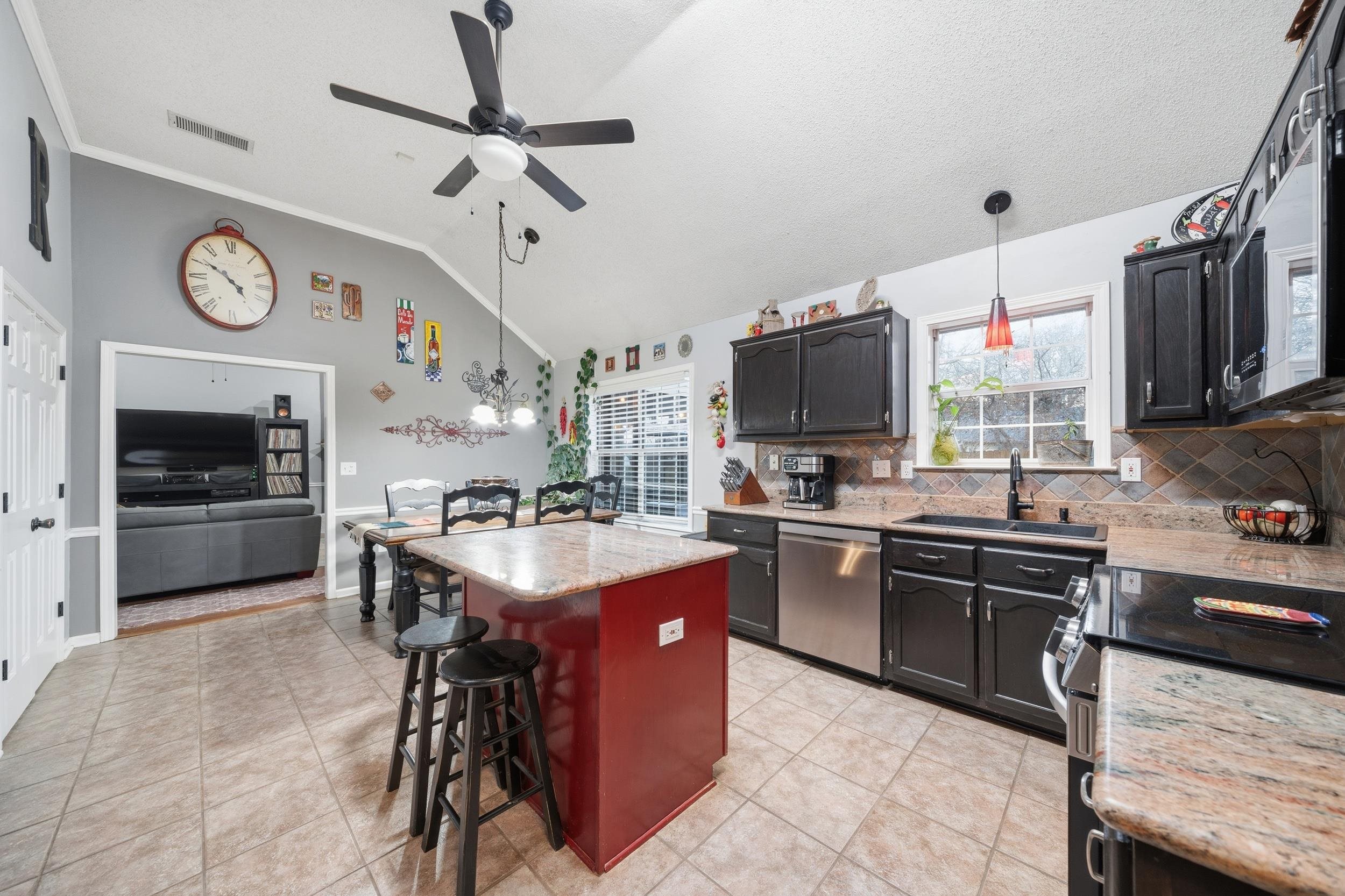 307 John Cove Collierville, TN 38017 - Photo 23 of 25 Kitchen with a kitchen island, stainless steel appliances, hanging light fixtures, a kitchen breakfast bar, and light stone countertops