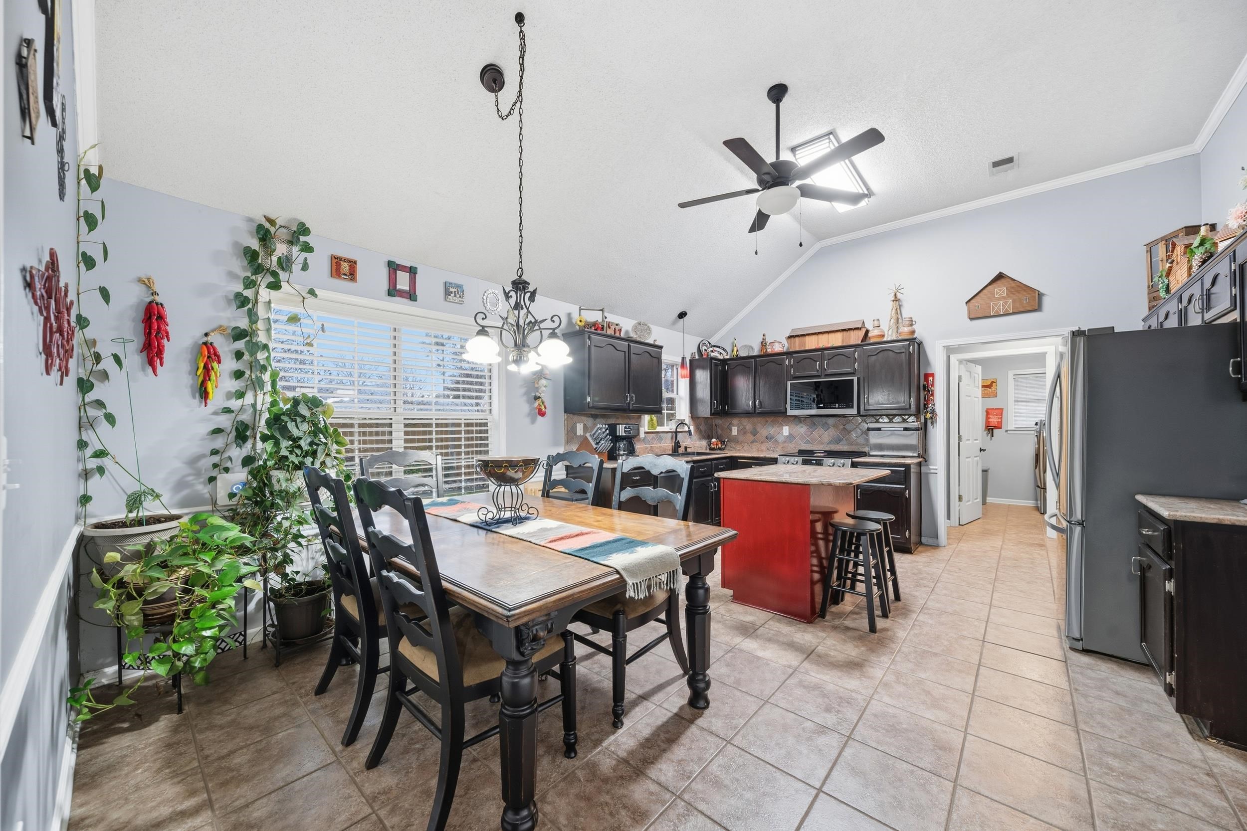 307 John Cove Collierville, TN 38017 - Photo 24 of 25 Dining area featuring a chandelier, ceiling fan, vaulted ceiling, light tile patterned flooring, and ornamental molding