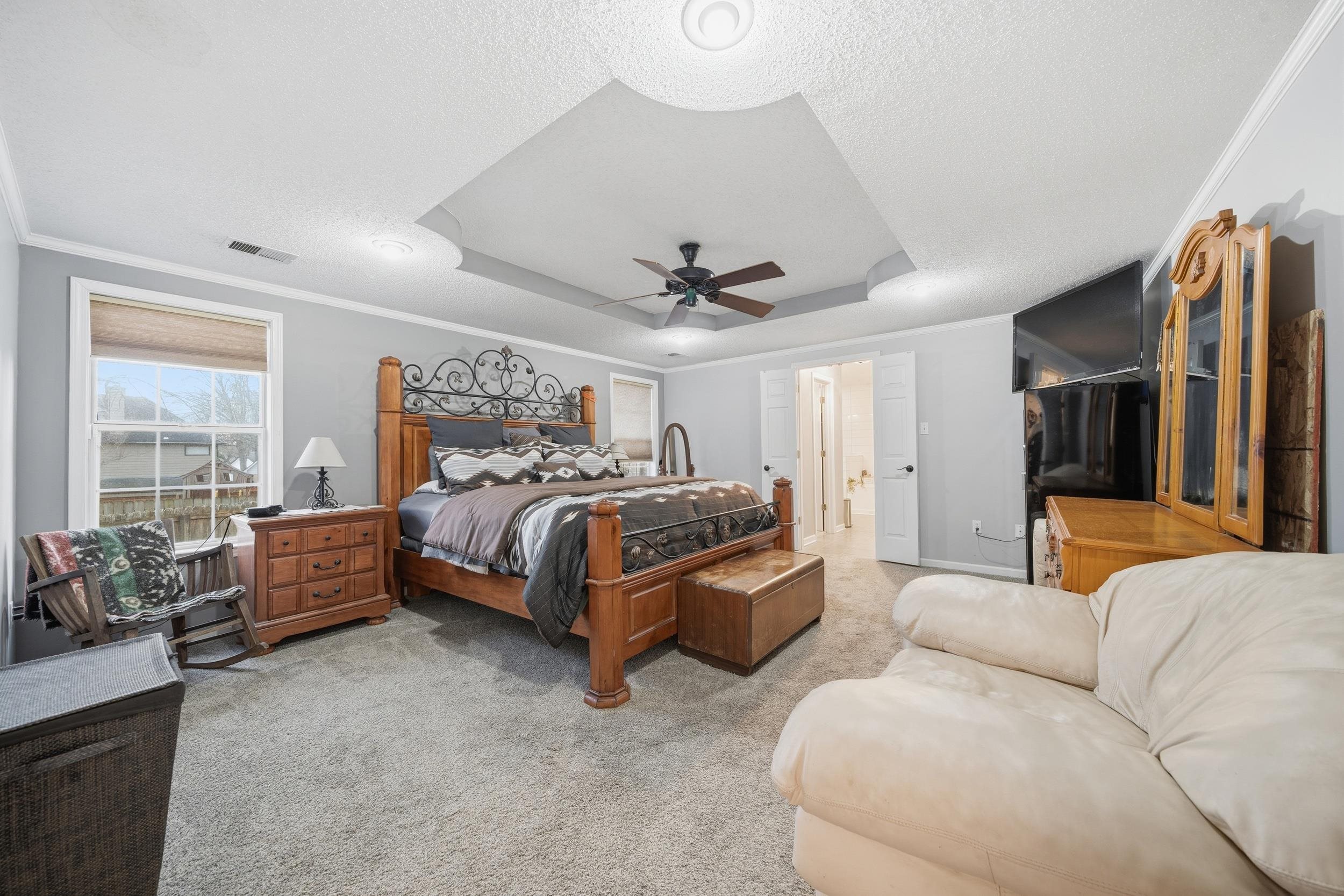 307 John Cove Collierville, TN 38017 - Photo 3 of 25 Bedroom with light carpet, crown molding, a raised ceiling, a ceiling fan, and a textured ceiling