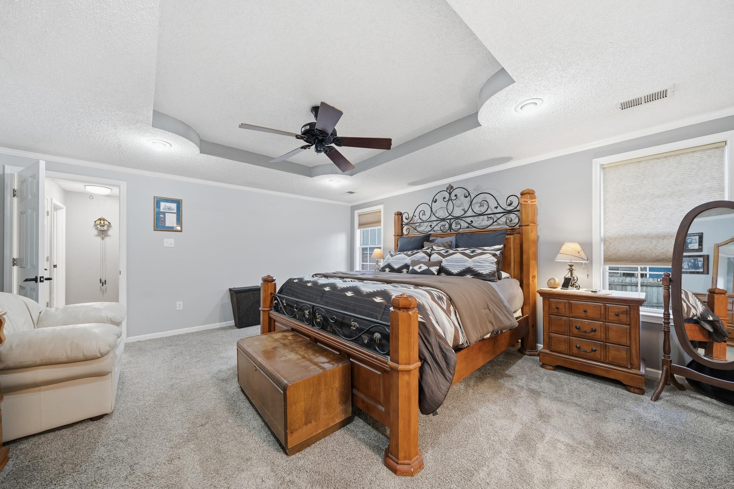 307 John Cove Collierville, TN 38017 - Photo 4 of 25 Bedroom with crown molding, light carpet, ceiling fan, a textured ceiling, and a raised ceiling