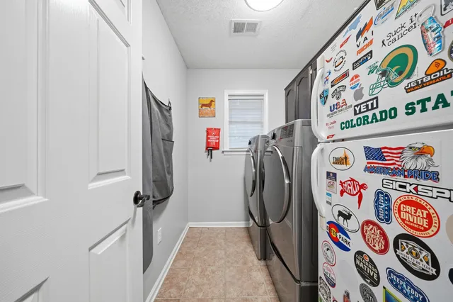 a utility room with fridge and black white wall & door