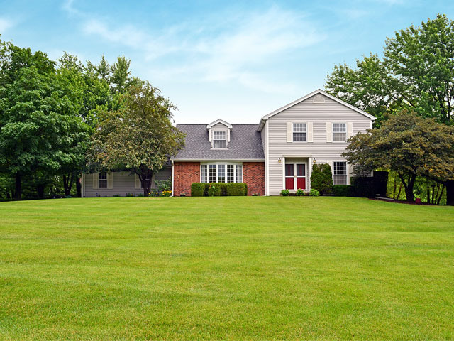 a front view of a house with a yard and trees