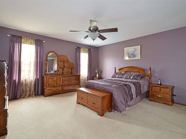 587 Scots Court Inverness, IL 60067 - Photo 8 of 18 a bedroom with a bed and a chandelier