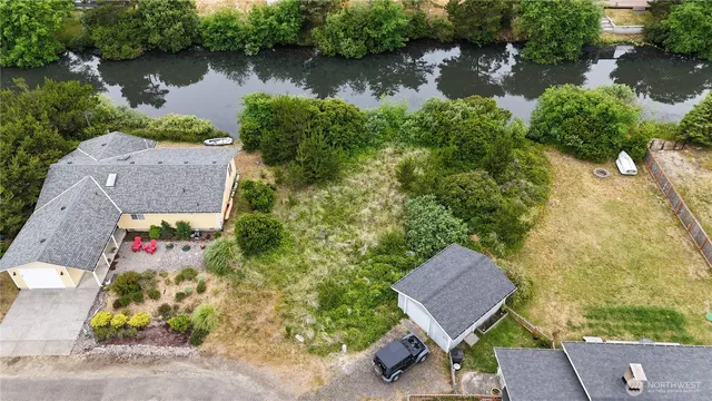 an aerial view of a house with a yard and lake view