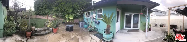 a view of a house with a potted plant and floor to ceiling window