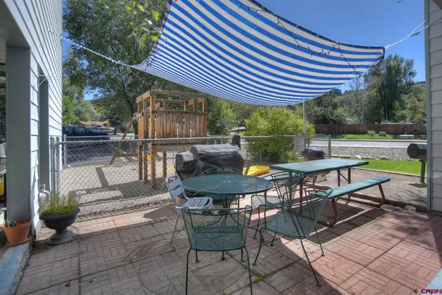 a view of a house with backyard and furniture