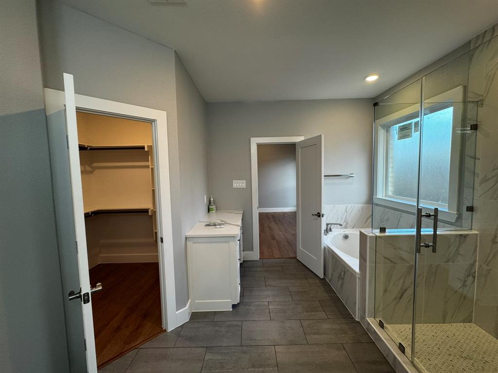 2533 Jonesboro Avenue Dallas, TX 75228 - Photo 17 of 27 a large bathroom with a double vanity sink a large mirror and a bathtub