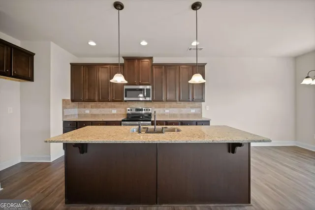 a kitchen with a sink a microwave a refrigerator and cabinets
