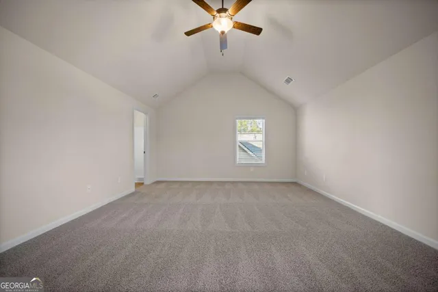 an empty room with window and ceiling fan