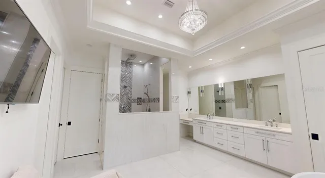 a large bathroom with a double vanity sink a large mirror and a shower
