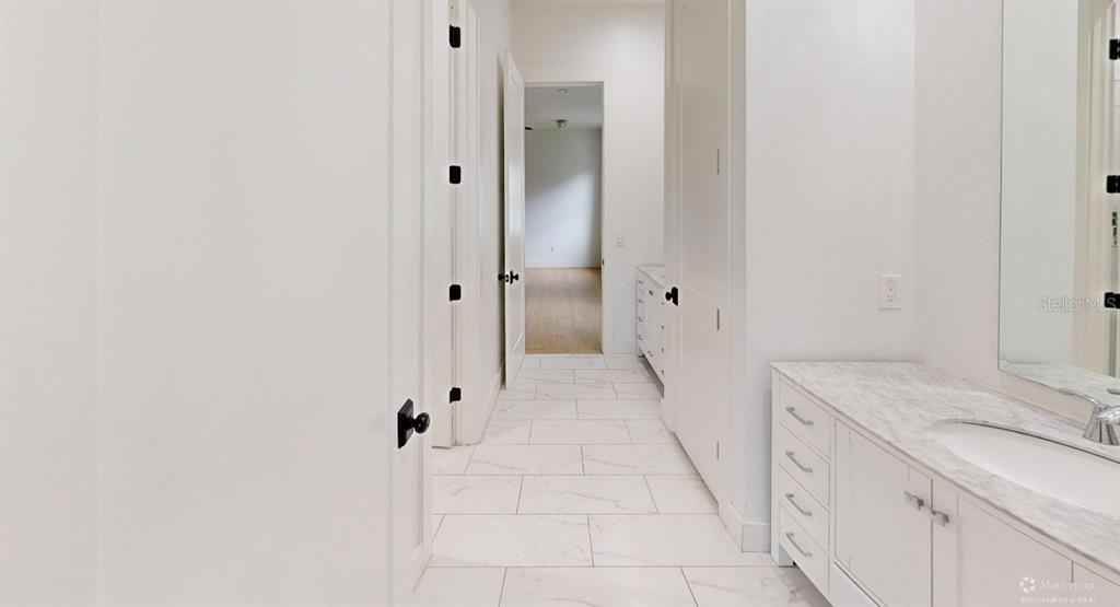 8241 Cass Road Zephyrhills, FL 33540 - Photo 19 of 25 a bathroom with a granite countertop sink a toilet and shower