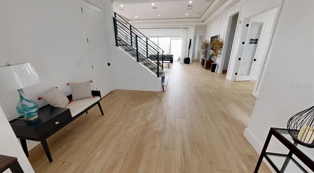 a room with lots of white furniture and stairs