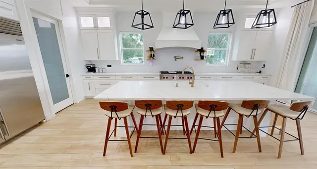 a kitchen with stainless steel appliances a table chairs and a refrigerator