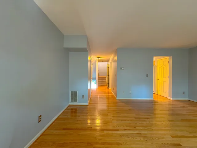 a view of empty room with wooden floor