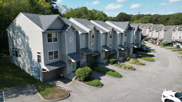 a view of a house with a yard and a car park in front of it