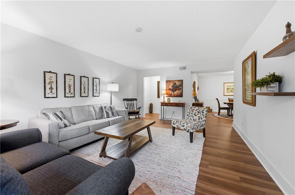 a living room with furniture wooden floor and a lamp