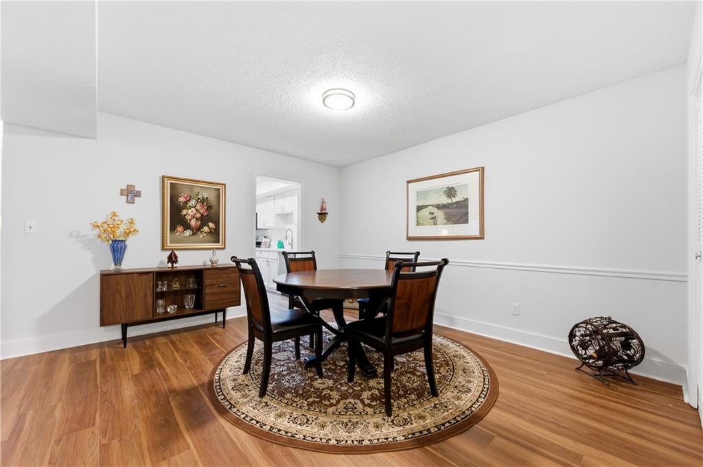 6851 Roswell Road, Unit F15 Atlanta, GA 30328 - Photo 11 of 31 a dining room with furniture and wooden floor