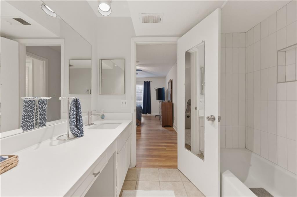 6851 Roswell Road, Unit F15 Atlanta, GA 30328 - Photo 15 of 31 a bathroom with a double vanity sink a mirror and shower