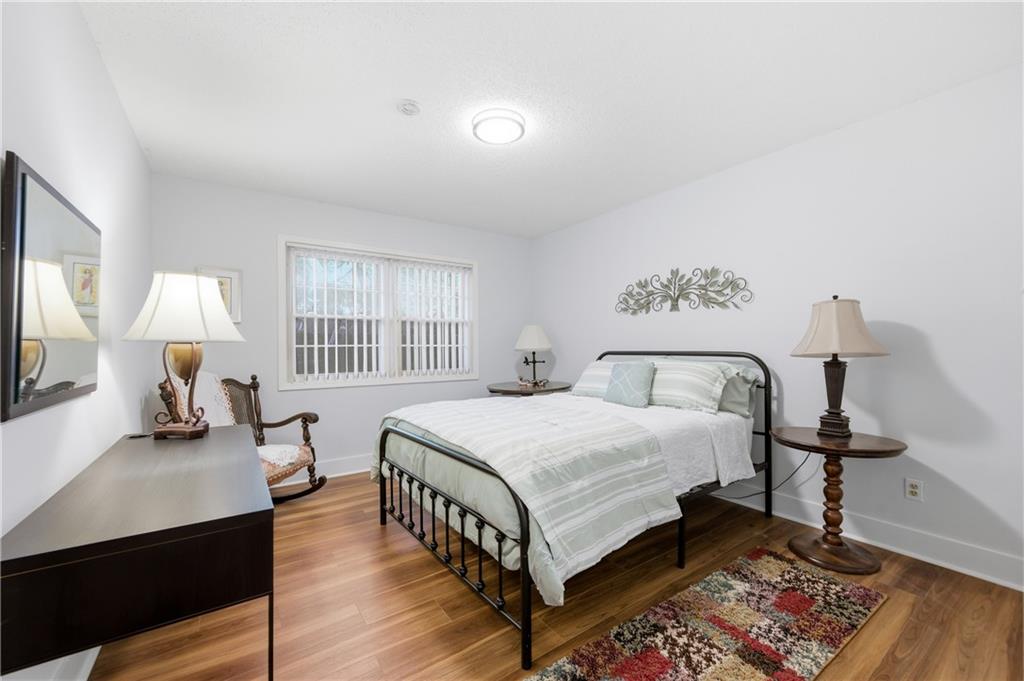 6851 Roswell Road, Unit F15 Atlanta, GA 30328 - Photo 18 of 31 a bed room with a bed a lamp and a window