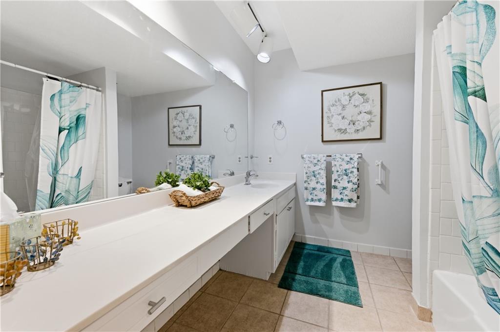 6851 Roswell Road, Unit F15 Atlanta, GA 30328 - Photo 21 of 31 a bathroom with a bathtub sink and mirror