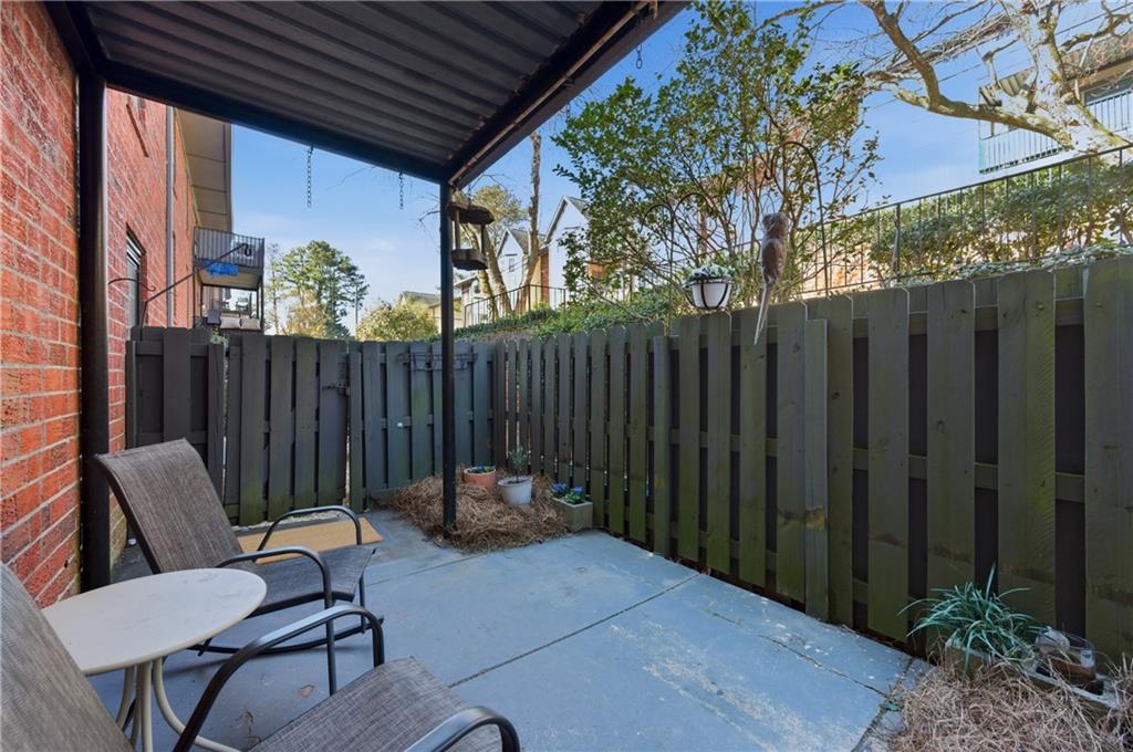6851 Roswell Road, Unit F15 Atlanta, GA 30328 - Photo 24 of 31 a backyard of a house with table and chairs