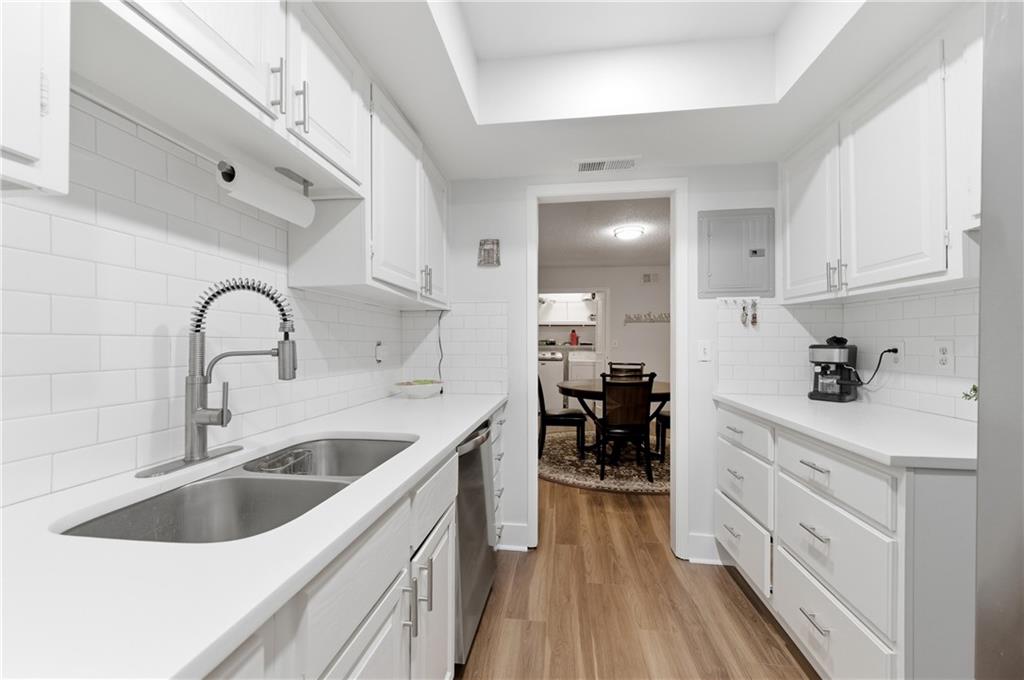 6851 Roswell Road, Unit F15 Atlanta, GA 30328 - Photo 5 of 31 a kitchen with a sink white cabinets and white appliances