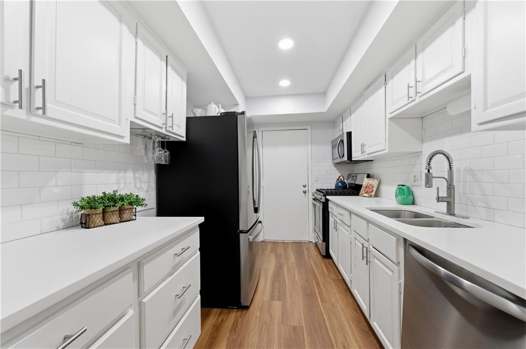 6851 Roswell Road, Unit F15 Atlanta, GA 30328 - Photo 7 of 31 a kitchen with sink a refrigerator and cabinets