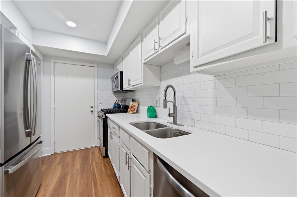 6851 Roswell Road, Unit F15 Atlanta, GA 30328 - Photo 8 of 31 a kitchen with a sink a refrigerator and cabinets