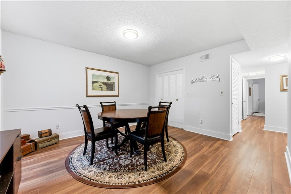 6851 Roswell Road, Unit F15 Atlanta, GA 30328 - Photo 9 of 31 a view of a dining room with furniture and wooden floor