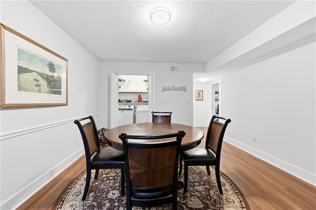 6851 Roswell Road, Unit F15 Atlanta, GA 30328 - Photo 10 of 31 a view of a dining room with furniture and wooden floor