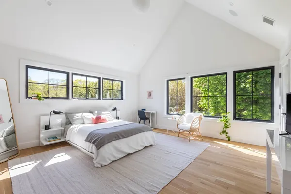 a bedroom with a large bed and windows