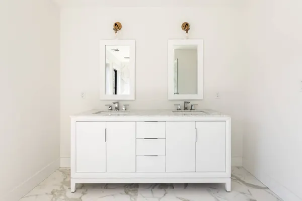 a bathroom with double sink and a mirror