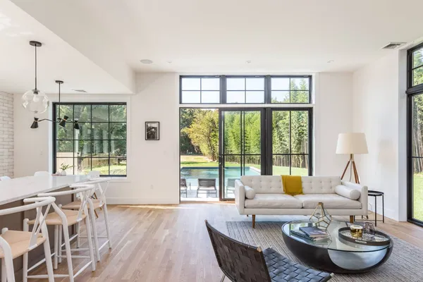 a living room with furniture and a large window with garden view