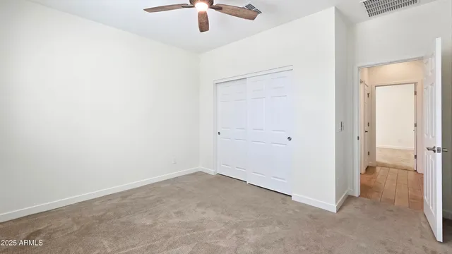an empty room with a ceiling fan and a window
