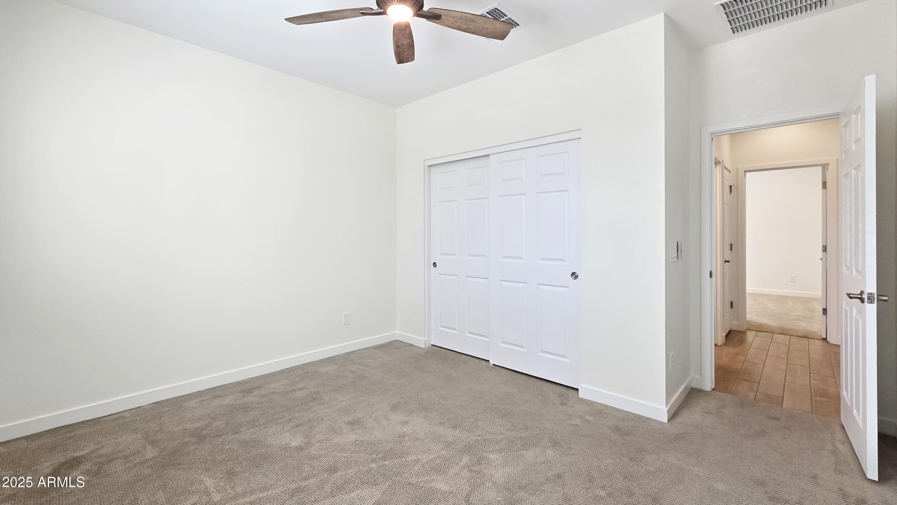 17864 West Thistle Landing Drive Goodyear, AZ 85338 - Photo 15 of 43 an empty room with a ceiling fan and a window