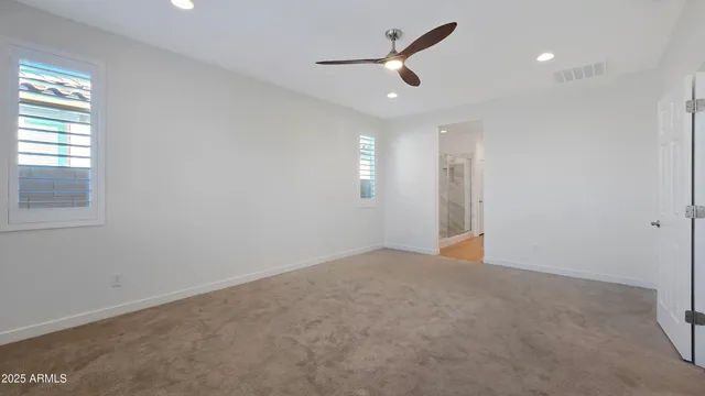an empty room with closet and windows