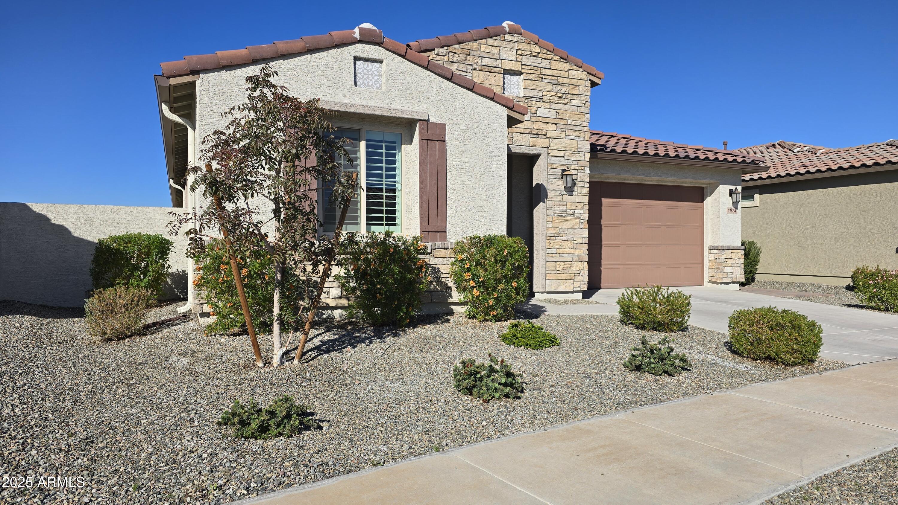17864 West Thistle Landing Drive Goodyear, AZ 85338 - Photo 2 of 43 a front view of a house with garden