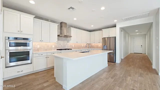 a large white kitchen with a stove top oven a sink and dishwasher with white cabinets