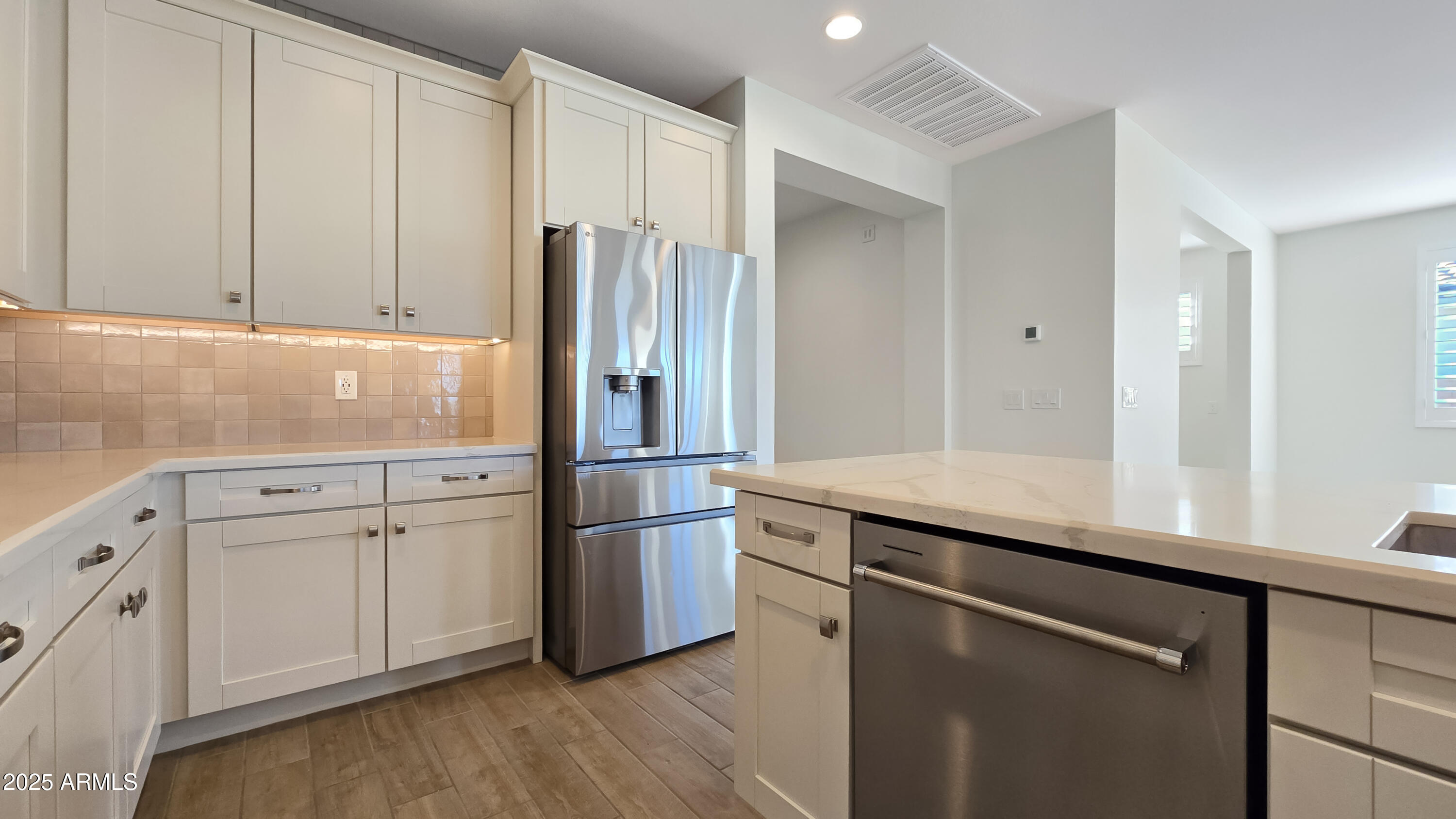 17864 West Thistle Landing Drive Goodyear, AZ 85338 - Photo 9 of 43 a kitchen with stainless steel appliances granite countertop a refrigerator and a sink