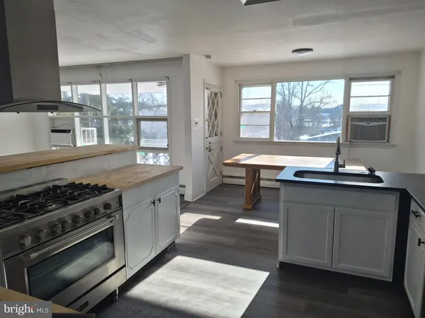 a large kitchen with stainless steel appliances a stove and a large window