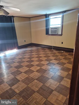 a view of a room with wooden floor and white walls