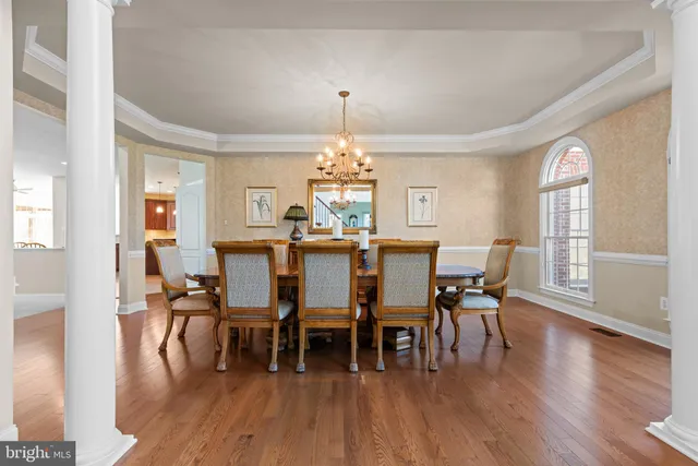 a dining hall with stainless steel appliances granite countertop a stove a sink a dining table and chairs