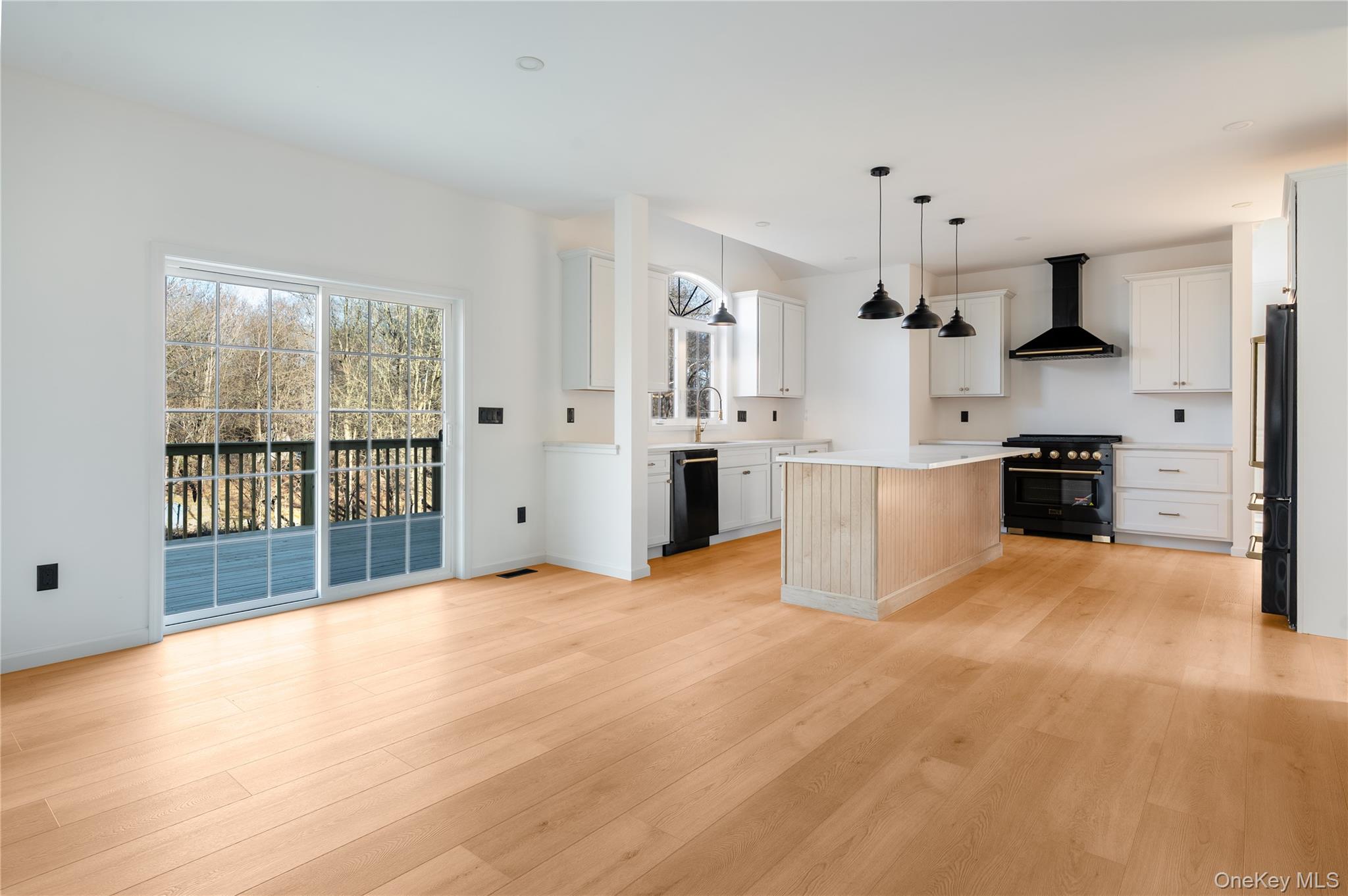 317 Hynes Road Poughquag, NY 12570 - Photo 5 of 12 Kitchen featuring hanging light fixtures, black appliances, wall chimney range hood, and light wood-style flooring