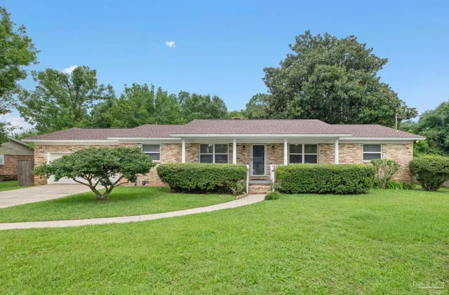 a view of a house with a yard and potted plants